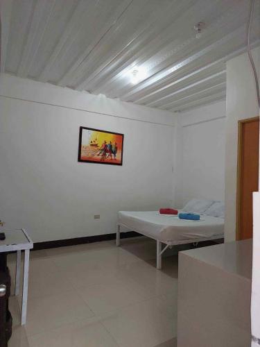 a room with a bed and a picture on the wall at RedDoorz at Wyns Hotel in Silañgang Mayao