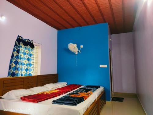 a bedroom with a blue wall and a bed at Sky View Resort in Yercaud