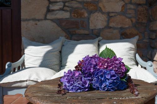 a bouquet of purple flowers on a wooden table at El currillo preciosa casa rural al lado cabarceno in Argomilla