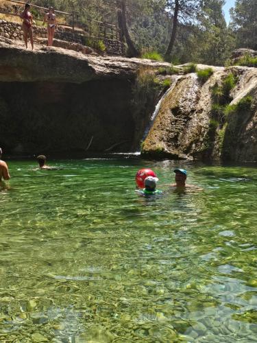 a group of people in the water near a waterfall at Mas del Bot in Valderrobres