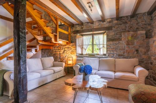 a living room with two couches and a table at El currillo preciosa casa rural al lado cabarceno in Argomilla