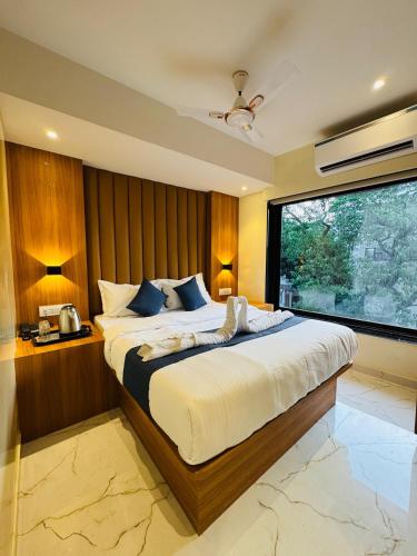 a bedroom with a large bed and a large window at Hotel Comfort Castle in Mumbai