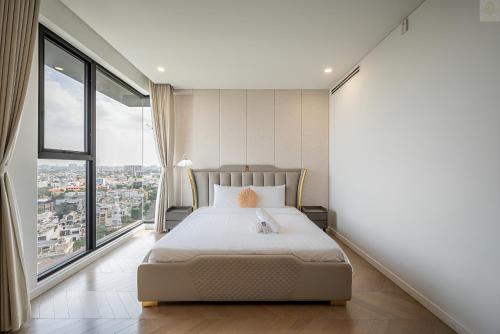 a bedroom with a bed and a large window at Lumiere Horizon Suites in Ho Chi Minh City