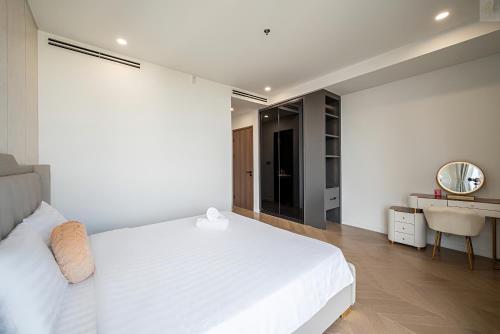 a bedroom with a white bed and a desk at Lumiere Horizon Suites in Ho Chi Minh City