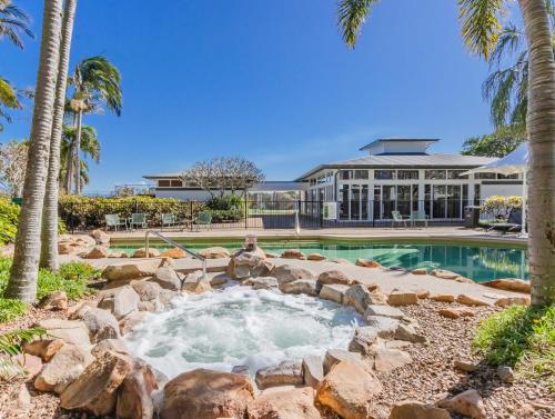 a backyard pool with a hot tub and a building at The Pool Resort Kingscliff - Private Apartments by Holiday Management Company in Kingscliff