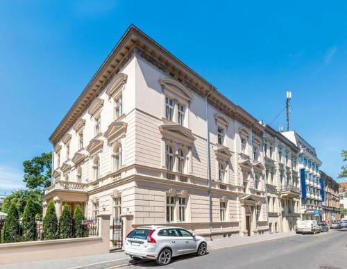 Un edificio blanco con un coche aparcado delante. en Great apartment in the Old Town, en Cracovia