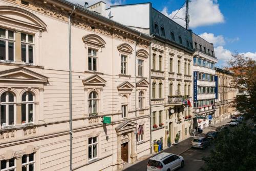 un gran edificio blanco con coches aparcados en una calle en Great apartment in the Old Town, en Cracovia