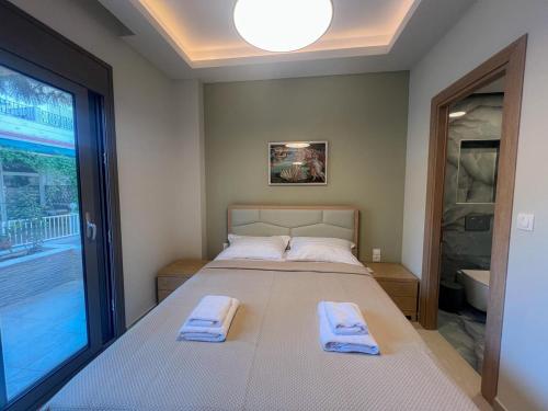 a bedroom with a bed with two towels on it at SeaNest Luxury Accomodation Hanioti in Hanioti