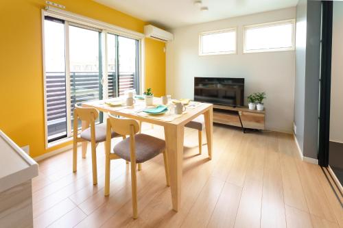 a dining room with a table and chairs and a tv at Stay&resort Luce ルーチェ in Urayasu