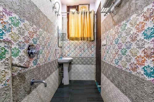 baño con lavabo y cortina amarilla en Mayank Residency, en Dehradun