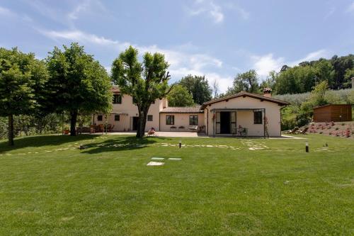 a house with a large yard in front of it at LA COLLINA DEGLI ULIVI 8&2, Emma Villas in Montefalco