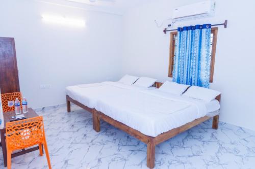 a bedroom with a bed and a side table and a bed sidx sidx at Auro Ocean View Residency in Pondicherry