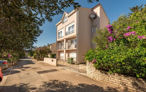 an apartment building on a street with flowers at 2 Bedroom Awesome Apartment In Zadar in Zadar