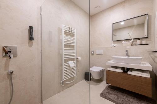 Un baño con lavabo y ducha de cristal. en Villa Castanea, en Heki
