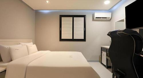 a bedroom with a white bed and a window at Chuncheon World Hotel in Chuncheon