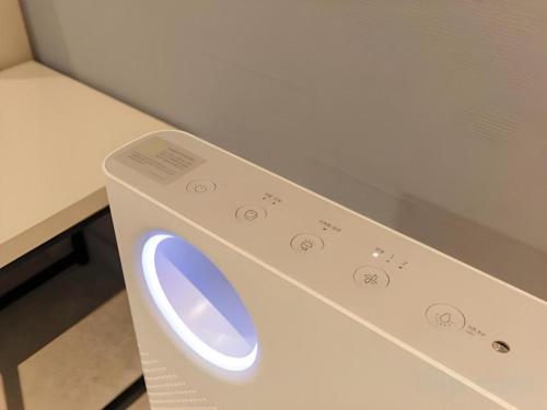 a white washing machine with a blue button on it at Chuncheon World Hotel in Chuncheon