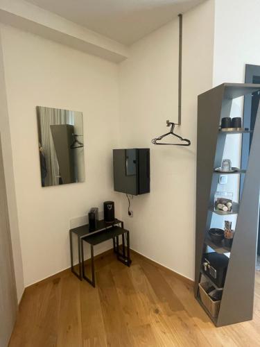 a room with a table and a tv on a wall at Nõs Luxury Rooms in Mesolongion