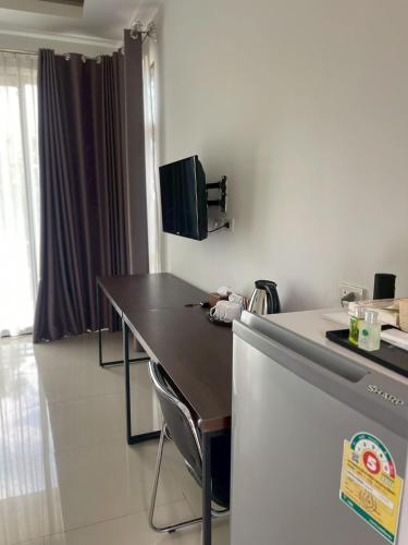 a kitchen with a table and a tv on the wall at Nutchana Hill Boutique Hotel in Ban Thung Ri