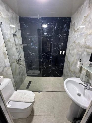 a bathroom with a shower and a toilet and a sink at Beshchinor Hotel in Yakkasaray