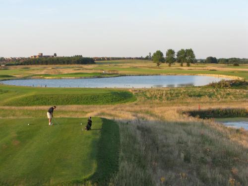 a man and a child playing golf on a golf course at Heacham Manor Hotel in Hunstanton