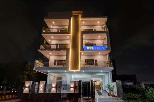 a tall white building with a blue sign on it at FabHotel The Glampoint in Noida