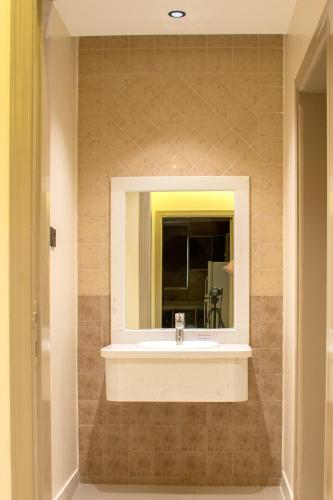 a bathroom with a sink and a mirror at ﺳﹻﻠﹿﺲ ﻟﻠﺸﻘﻖ اﻟﻤﺨﺪومة - الروابي in Riyadh