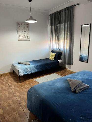 a bedroom with two beds and a window at Paloma Caparica Beach in Costa da Caparica