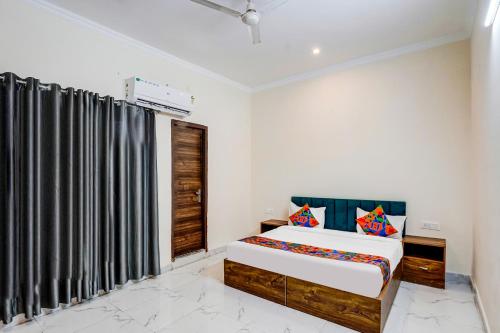 a bedroom with a bed and a window at FabHotel The Glampoint in Noida
