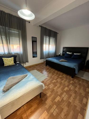 a bedroom with two beds and aokedokedoked at Paloma Caparica Beach in Costa da Caparica