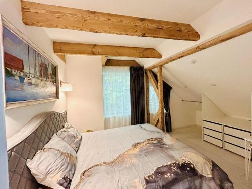 a bedroom with a large bed in a attic at Apartamentai senamiestyje Klaipėdos inkarai in Klaipėda