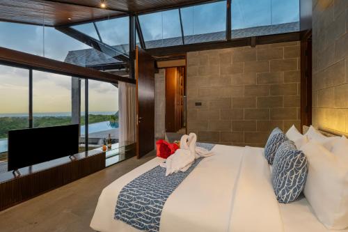 een slaapkamer met een groot bed en een tv bij Khaya Luxury Villas Nusa Dua in Nusa Dua