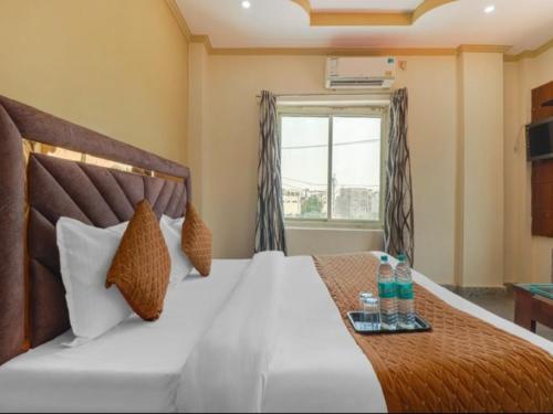 a bedroom with a bed with a tray of drinks on it at Ganga Palace in Haridwār