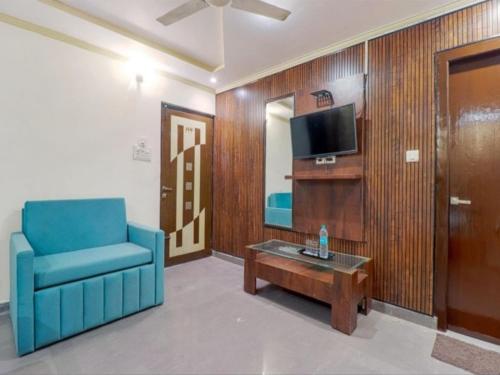 a living room with a blue chair and a coffee table at Ganga Palace in Haridwār
