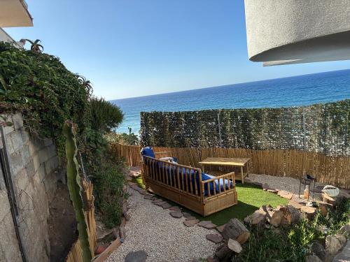 a garden with a bench and the ocean in the background at La Medusa in La Ciaccia