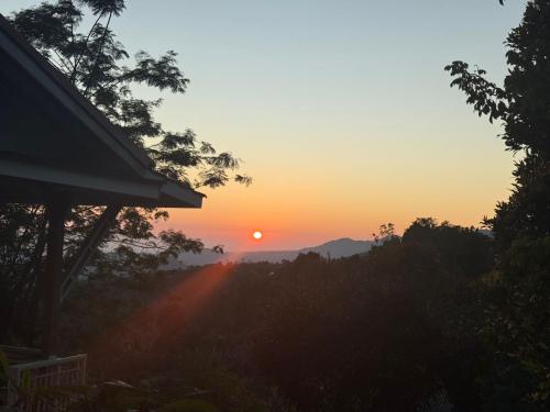 a sunset with the sun setting in the distance at green slope villa glamping in Gitgit