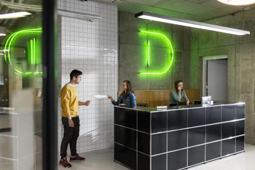 three people standing at a counter in an office at Domeq in Komárov
