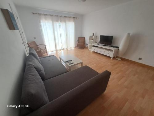 salon z kanapą i telewizorem w obiekcie Bonito apartamento reformado en Las Coronas w Costa Teguise