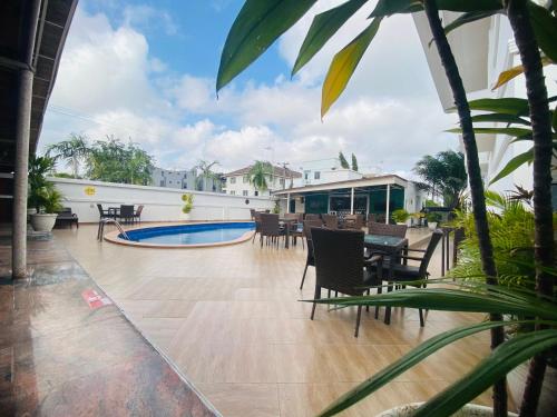 a patio with a table and chairs and a pool at PRESKEN WHITE HOUSE in Lagos