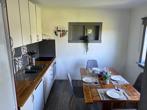 una pequeña cocina con mesa de madera y fregadero en Haus Harald, en Tysnes