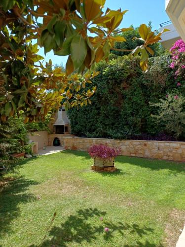 a yard with a garden with a hedge and flowers at Apartment with a garden, BBQ, swimming pool and jacuzzi in Drafí