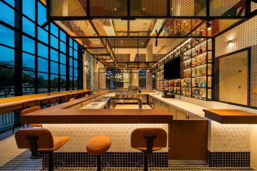 a restaurant with a bar and some chairs and windows at HIIVE by fusion Binh Duong New City - VSIP 2 in Thu Dau Mot