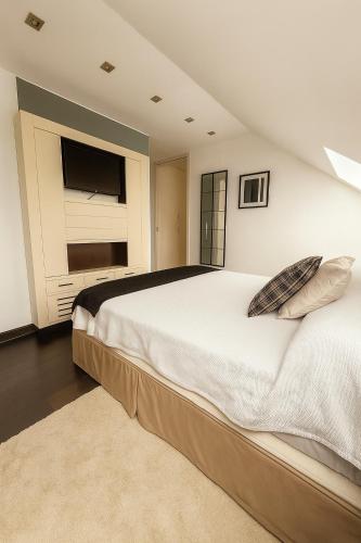 a bedroom with a large white bed and a window at Apartamentos Turisticos de Soria Moreras in Soria