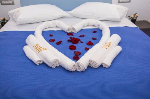 a heart made out of towels on a bed at Nalu Suites in Fira