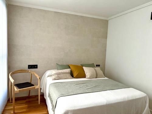 a small bedroom with a bed and a chair at Sindical in Castellón de la Plana
