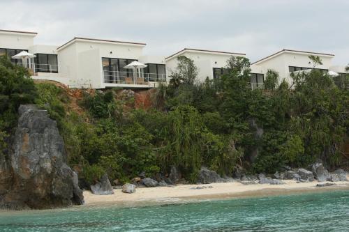 a house on a hill next to the ocean at アイネスヴィラノッツェ沖縄 in Nago