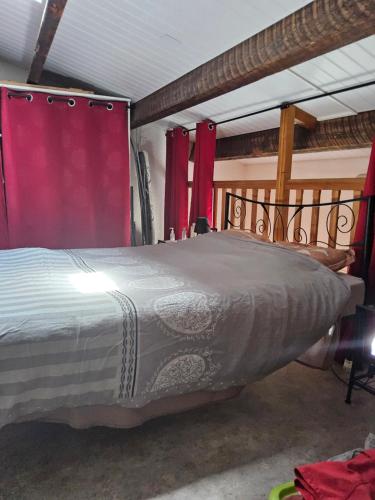 RARE maison du pêcheur en première ligne avec clim في لو باركار: سرير كبير في غرفة مع ستائر حمراء