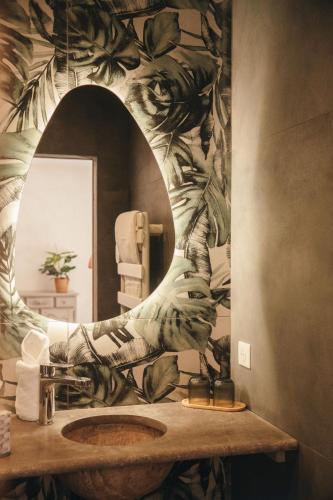 a bathroom with a sink with a large mirror at Domaine du PIAOU "chambres & table d'hôte" in Le Val