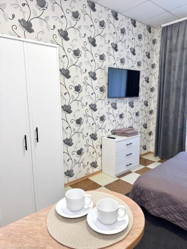 a room with a table with two cups and a tv at Hotel Vesta in Brovary