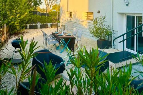 a patio with a table and chairs and plants at La Suite Saint Roch in Villeréal