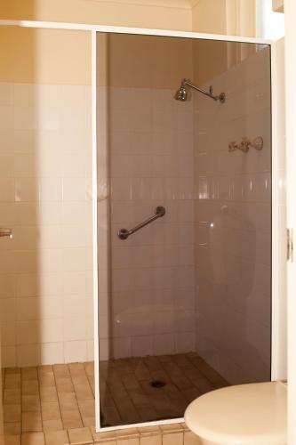 a shower with a glass door in a bathroom at Echuca Nirebo Motel in Echuca